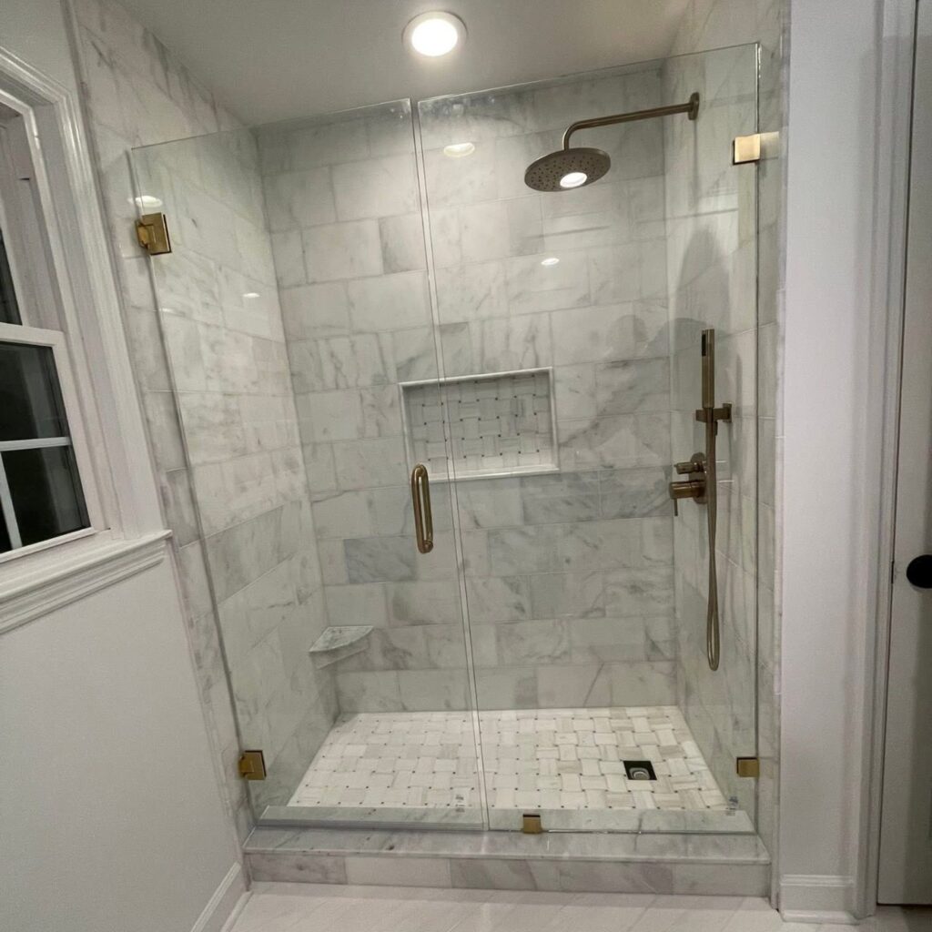 Marble shower with basketweave floor and brass fixtures