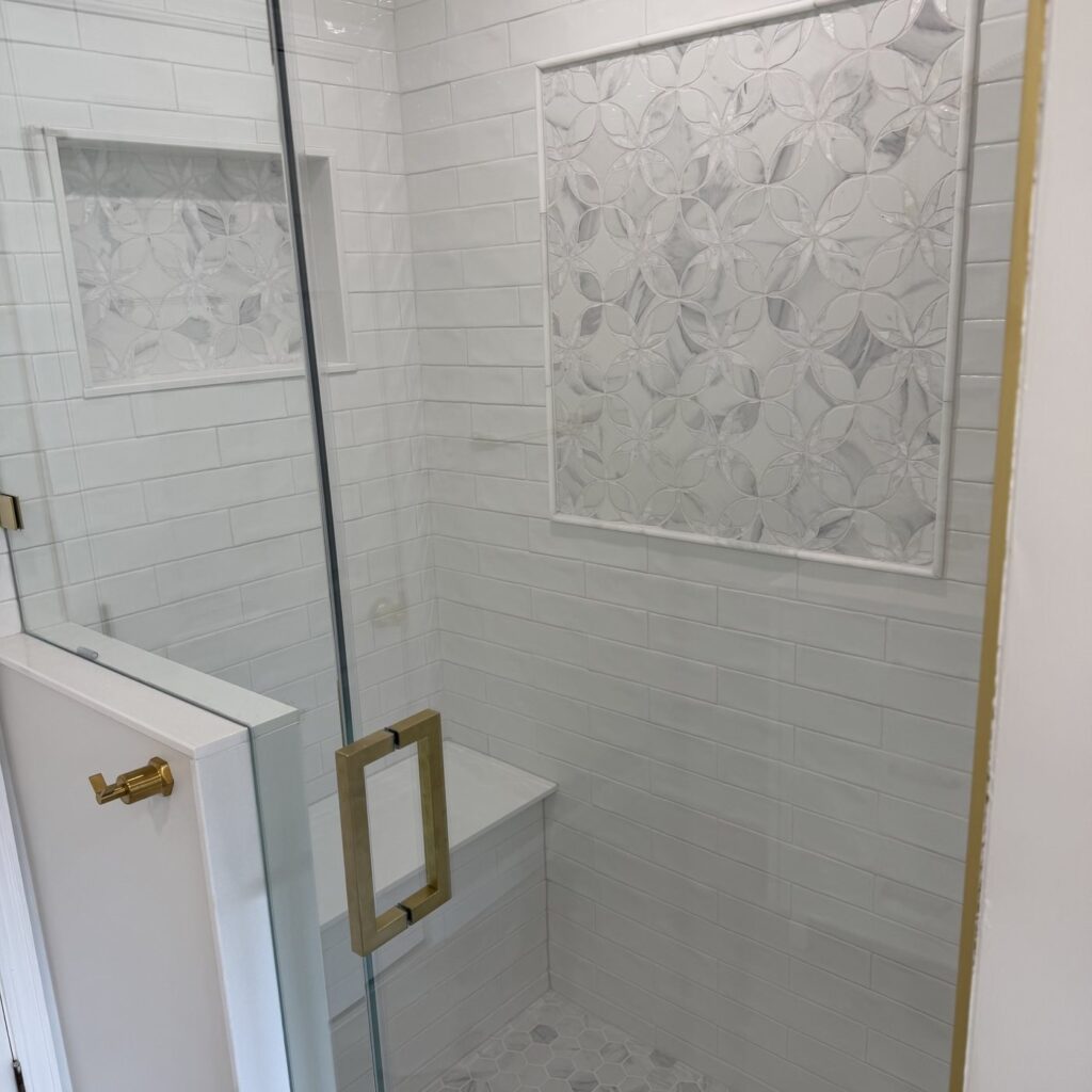 Marble shower with carved accent panel and bench